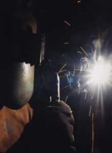 ) A welding student at the Jackson County Campus demonstrates skills he has learned as part of pre-employment welding training.
